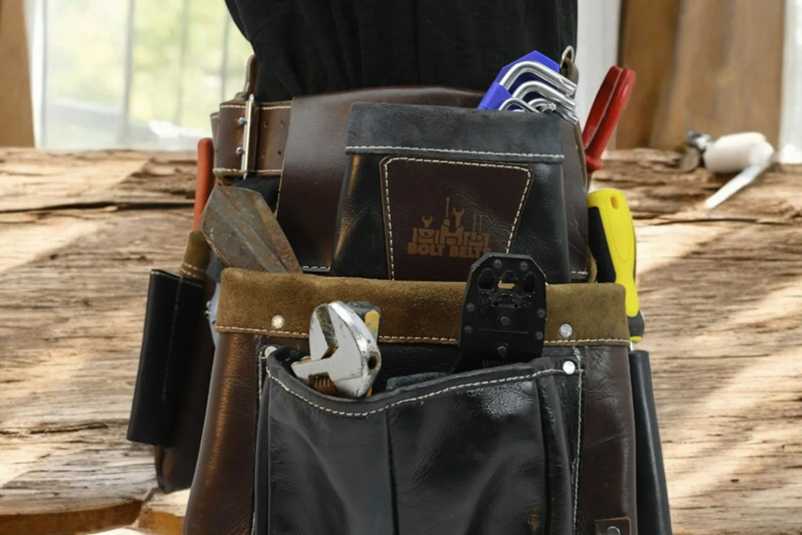 Leather tool belt full of tools on a workbench