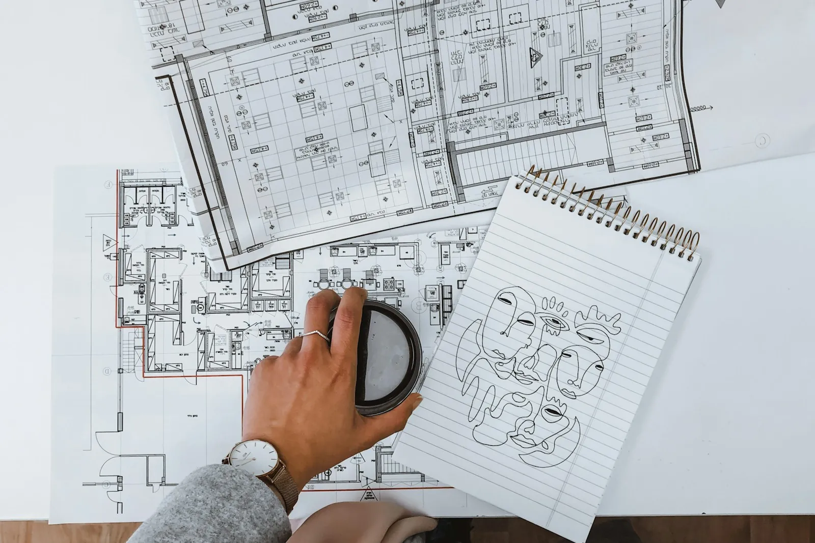 Hand working over detailed floor plans