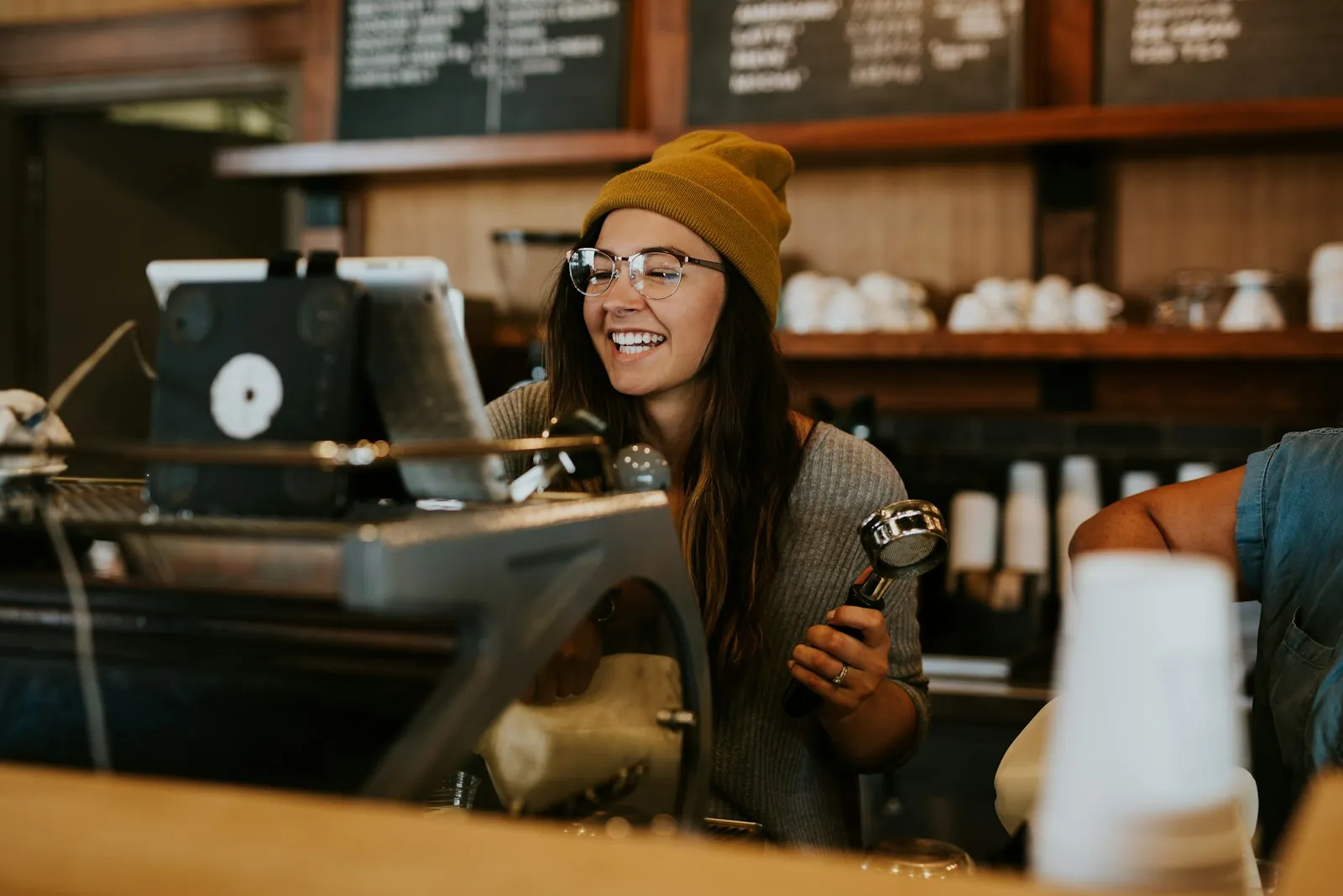 Smiling café owner at the coffee machine