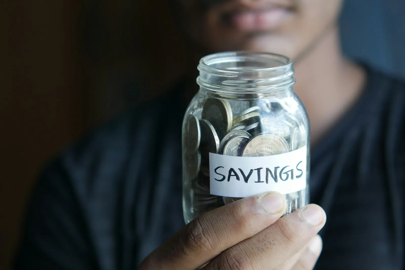 Person holding a jar of savings