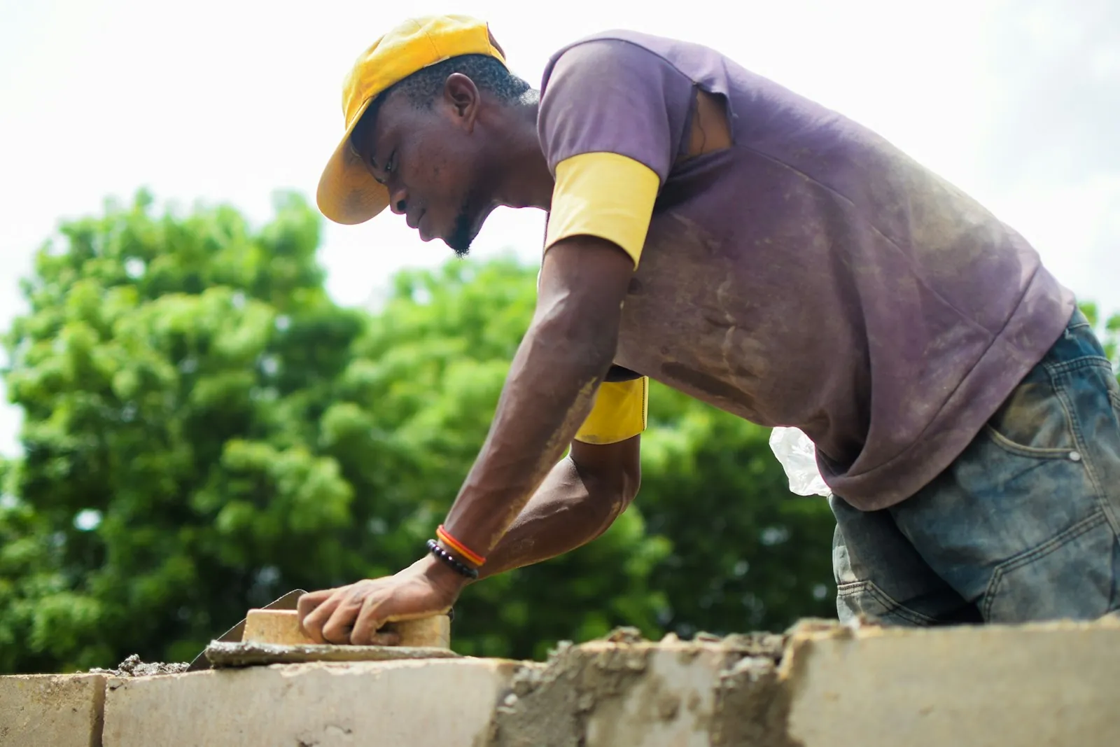 Bricklayer in a hard hat building a wall