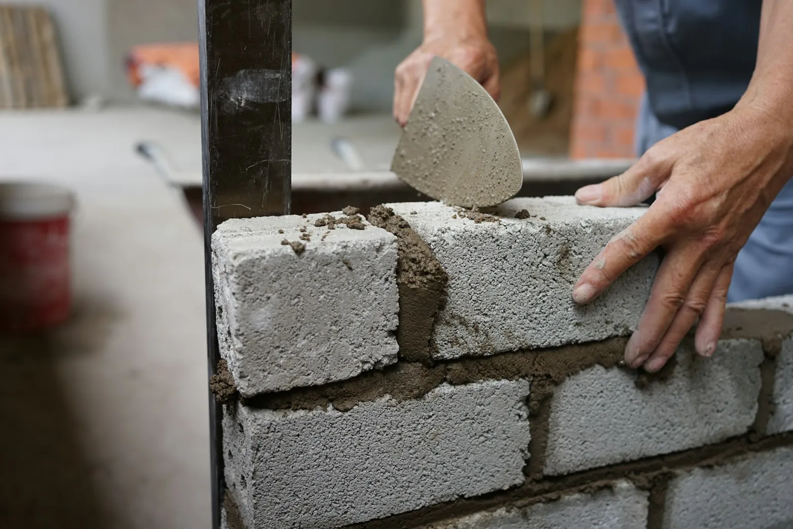 Builder laying blocks with a trowel