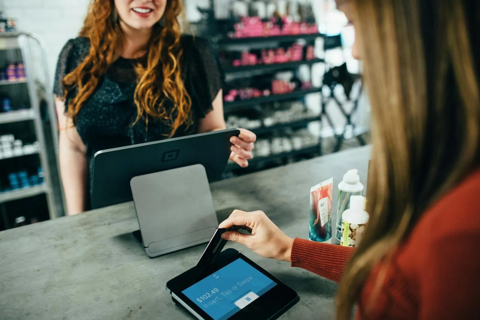 Customer paying by card at a shop till