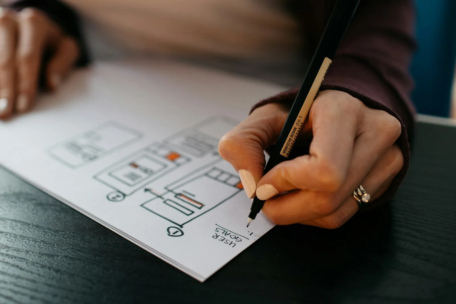 Hand sketching a website layout on paper