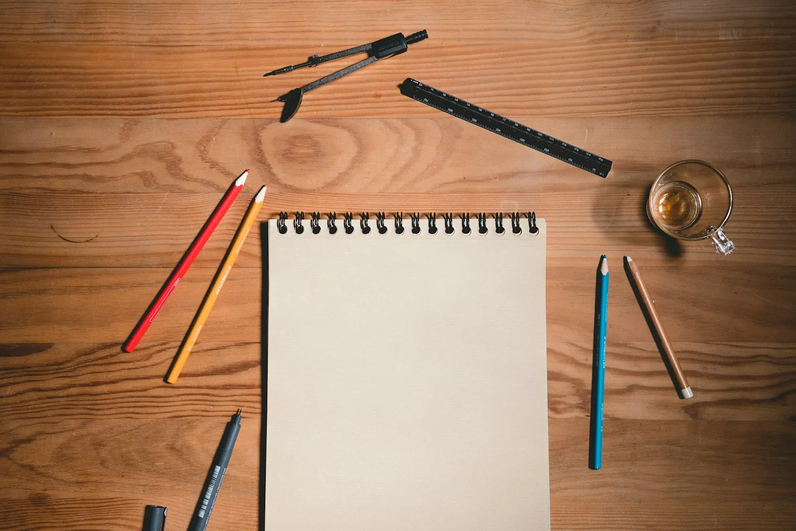 Sketchpad and pencils on a wooden desk, ready for planning