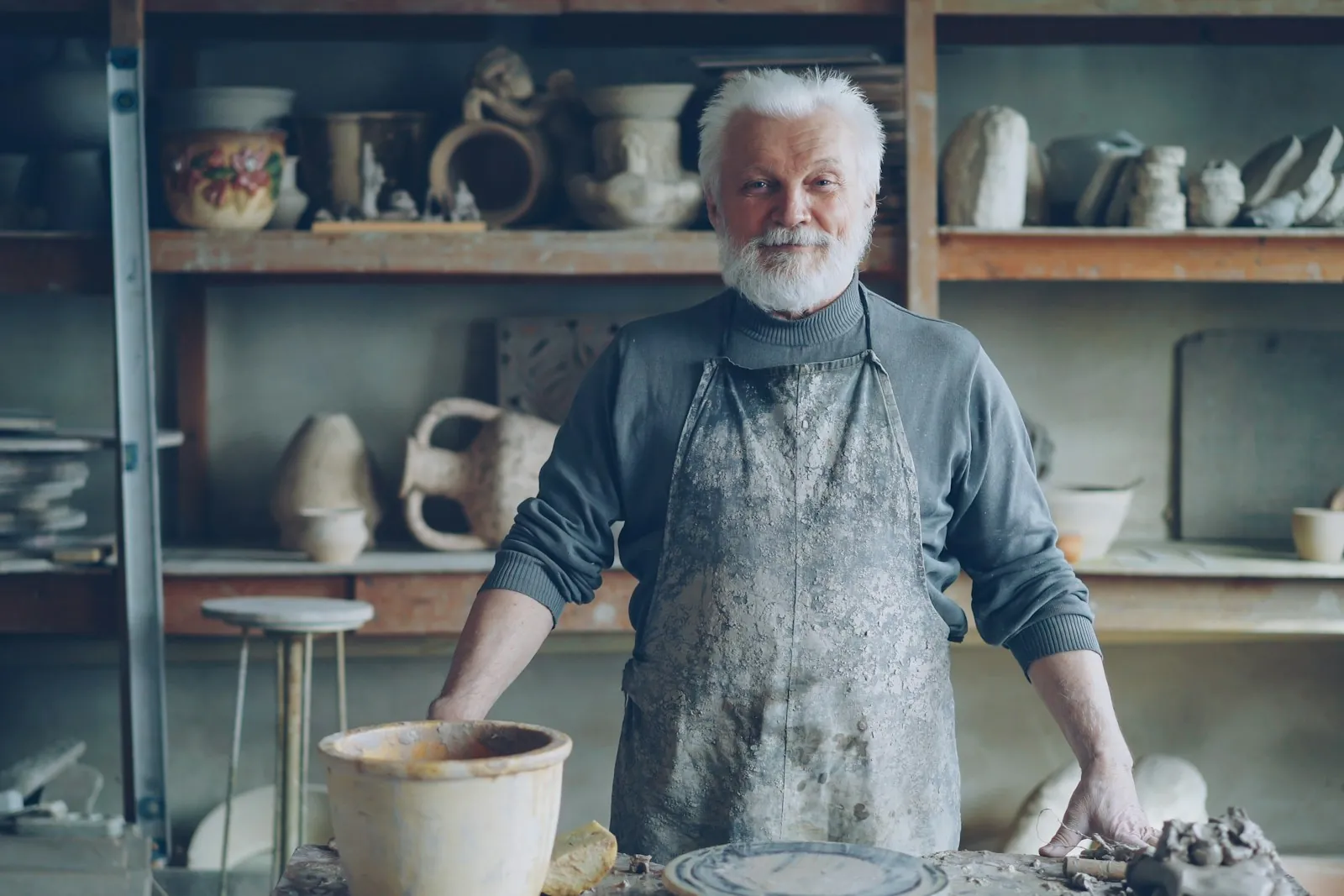 Proud potter standing in his workshop