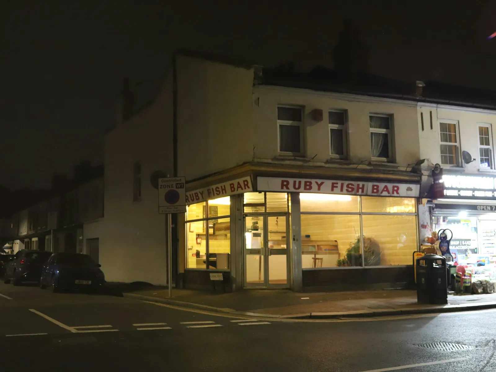 Fish and chip shop lit up at night on a British high street